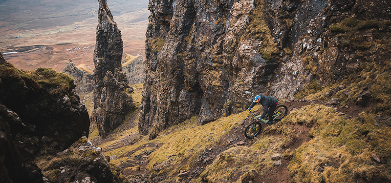 Santa Cruz Heckler in Gloss Avocado Green auf einem schmalen Trail bei einer Downhill Abfahrt