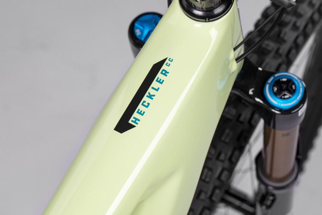 Blau/Schwarzes "Heckler CC" Logo auf dem Oberrohr in Gloss Avocado Green