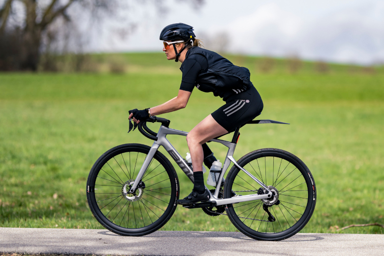 Eine weibliche gelesene Person fährt auf einer Roadmachine.