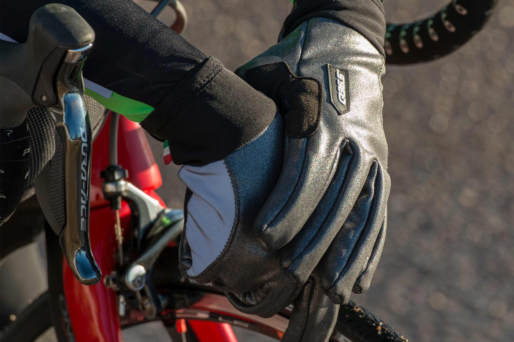 Eine Person sitzt auf einem Fahrrad und trägt Fahrradhandschuhe.