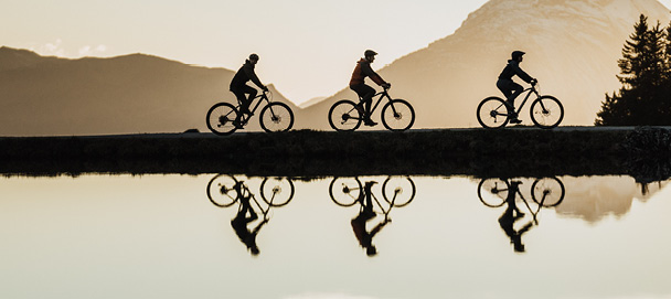 Drei Radfahrer in den Bergen.