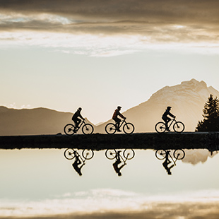 Drei Radfahrer vor einem Berg.